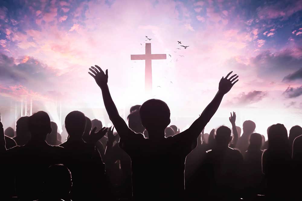 worship picture of a cross before a silohoutted crowd of people