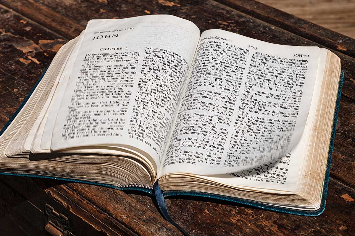 The Christian bible open to the book of John with pages blown by the wind